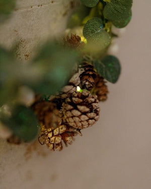 Rustic illuminated wreath featuring natural-style pinecones
