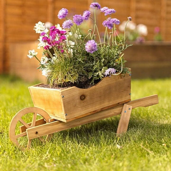 Wooden wheelbarrow planter displayed in garden