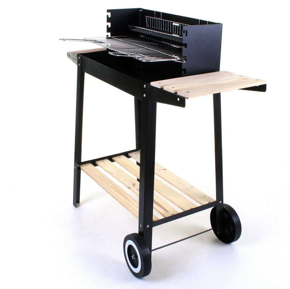 A black and wood outdoor charcoal grill with wheels, shown cooking food on a patio in front of a gray stone wall.