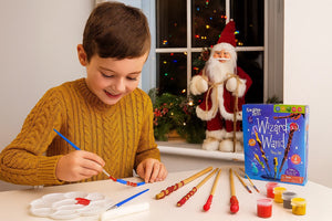 Child painting Wizard Wand toys with a Christmas scene in the background