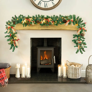 Decorated fireplace with Christmas garland, candles, and a clock above.