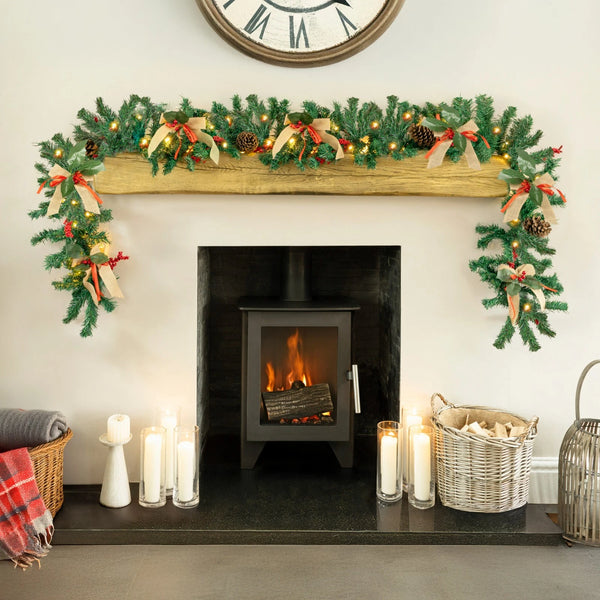 Decorated fireplace with Christmas garland, candles, and a clock above.