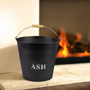 Black 'ASH' bucket on a fireplace hearth with flames in the background