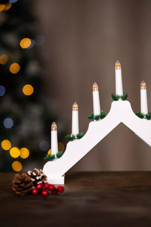 Decorative Advent wreath with white candles and pine cones on a dark background