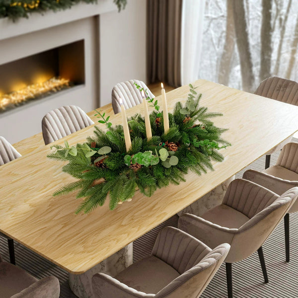 Dining table set with a festive centerpiece in a cozy room with a fireplace.
