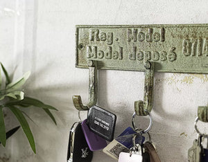 Vintage-style key holder with keys on a white wall