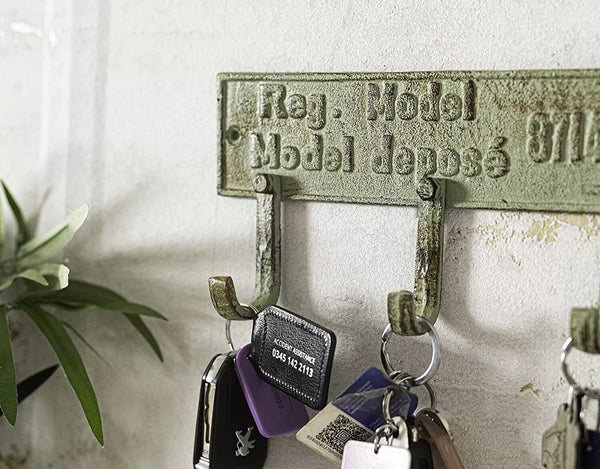 Vintage-style key holder with keys on a white wall