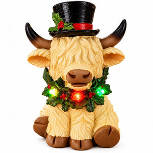 White Christmas Highland cow ornament with multicoloured LED lights on white background.
