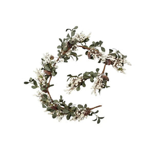 Decorative wreath with greenery and small white flowers on a white background