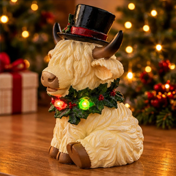 Side view of white Christmas Highland cow ornament with glowing LED wreath.