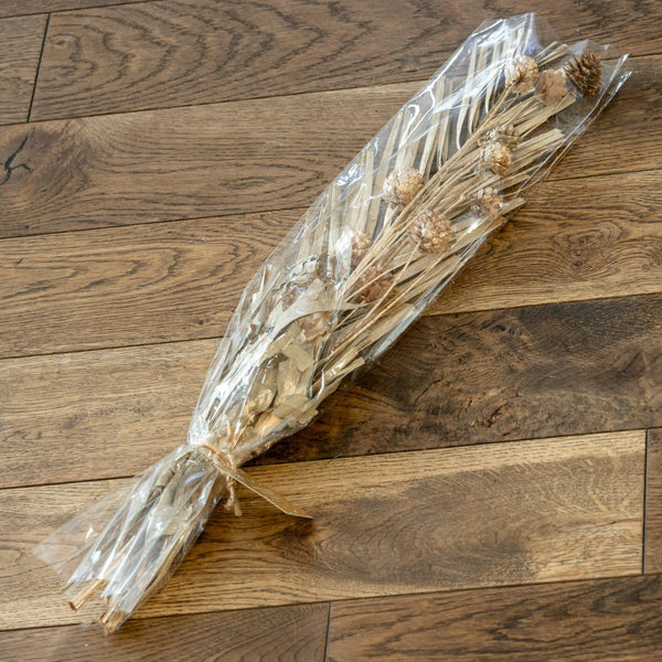 Bouquet of dried flowers in clear plastic wrap on a wooden floor