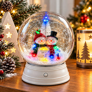 Christmas snow globe featuring two smiling snowmen illuminated by multicoloured LEDs.