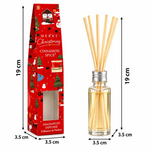 A Christmas-themed reed diffuser shown next to its red gift box with printed holiday illustrations. The diffuser has a clear glass bottle with pale amber liquid and several natural reed sticks, while the box is red with 'Merry Christmas Cinnamon Spice' text and dimensions marked in black lines.