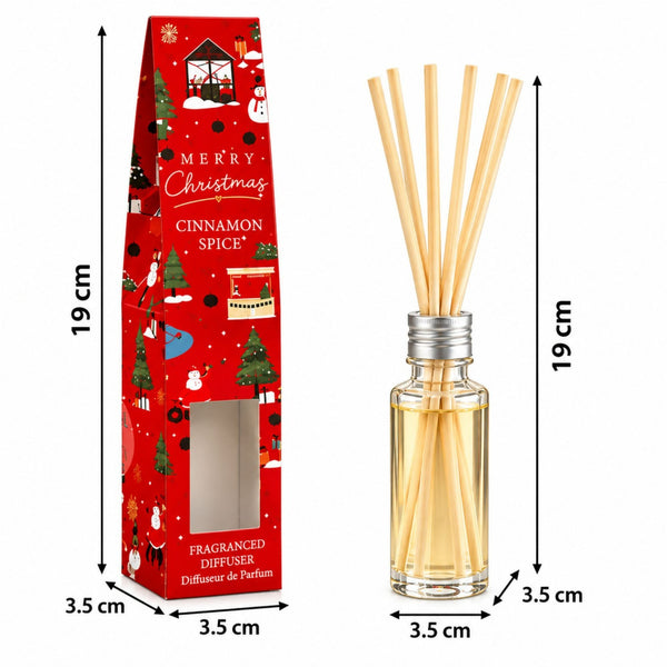 A Christmas-themed reed diffuser shown next to its red gift box with printed holiday illustrations. The diffuser has a clear glass bottle with pale amber liquid and several natural reed sticks, while the box is red with 'Merry Christmas Cinnamon Spice' text and dimensions marked in black lines.