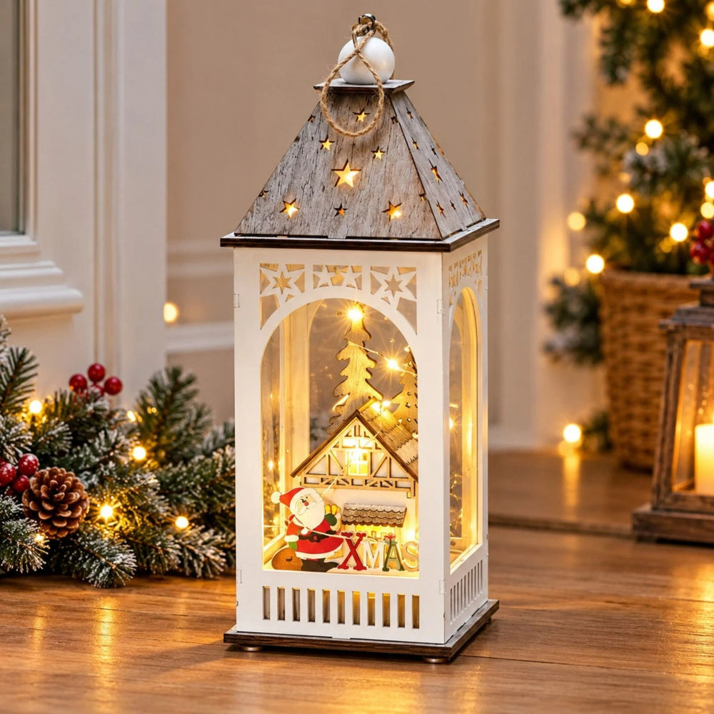 Light up Christmas lantern with Santa, cottage and festive greenery display.