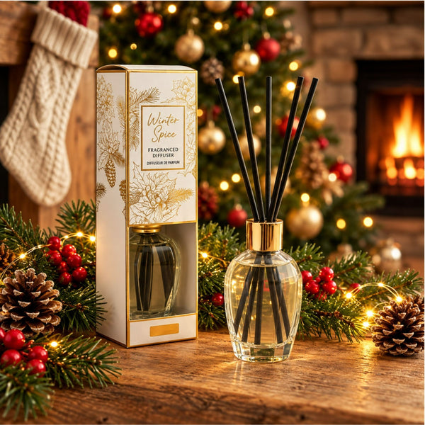 300ml Cinnamon Spice reed diffuser with black reeds and festive packaging beside Christmas decorations.