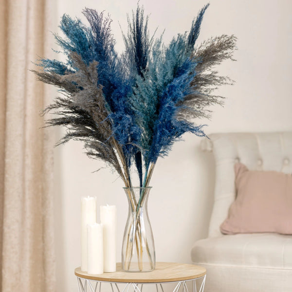 Decorative vase with blue and gray pampas grass on a side table in a living room.