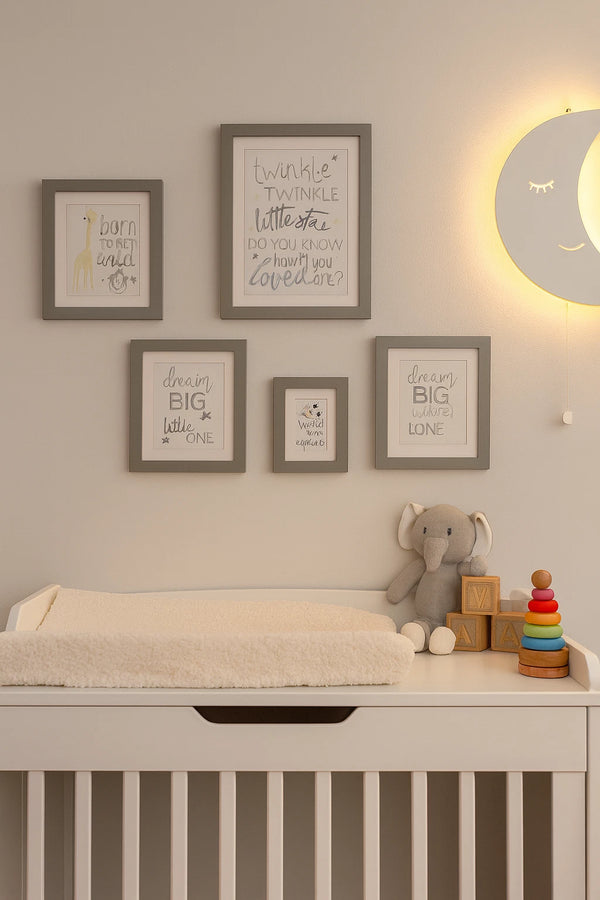 Nursery room with a changing table, toys, and framed quotes on the wall.