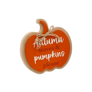 A pumpkin-shaped wooden sign with a bright orange center, natural wood border, and a small jute twine bow at the top. The sign reads 'Autumn leaves & pumpkins please' in white and dark brown lettering, shown on a plain white background.