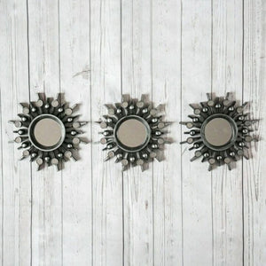 Three round silver wall mirrors displayed together