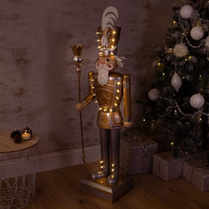 Silver and gold festive nutcracker standing indoors