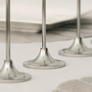 Three graduated silver candle holders with candles