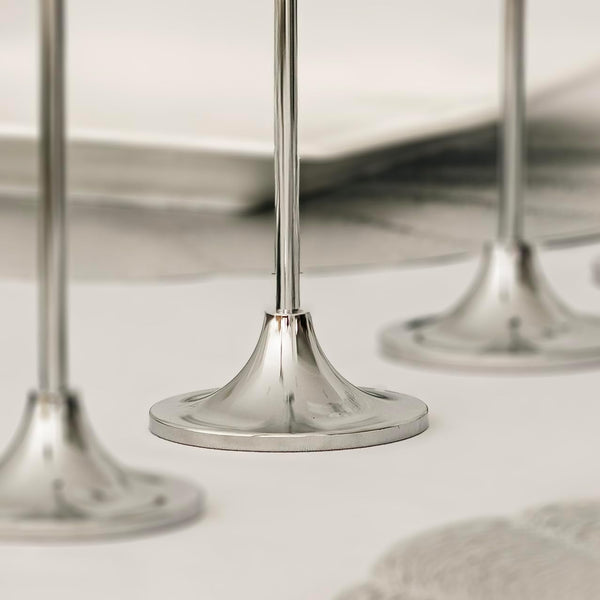 Three graduated silver candle holders with candles