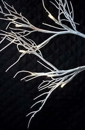 Silver glitter twig tree displayed on indoor table