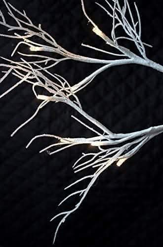 Silver glitter twig tree displayed on indoor table