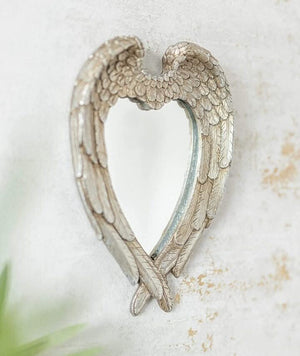 Decorative angel wing mirror displayed on wall
