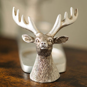 Three pillar candles arranged on a stag holder