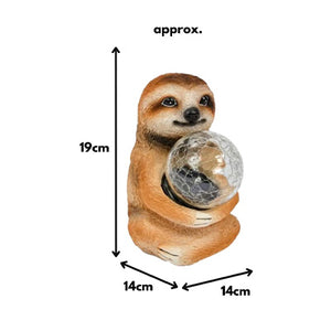 Polyresin sloth ornament displayed in garden flowerbed