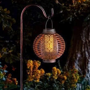 Flame effect lantern pair suspended beneath a pergola