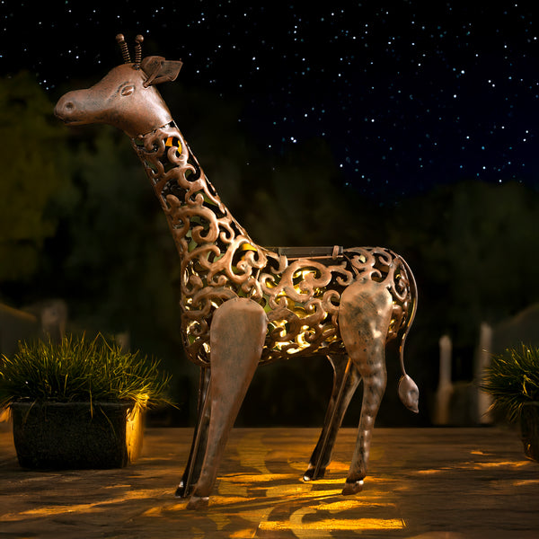 Solar powered giraffe decoration positioned in flower bed