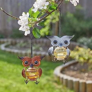 Solar powered owl ornament suspended from a tree branch