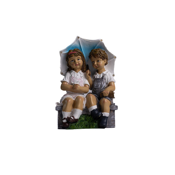 Boy and girl garden statue sitting on bench