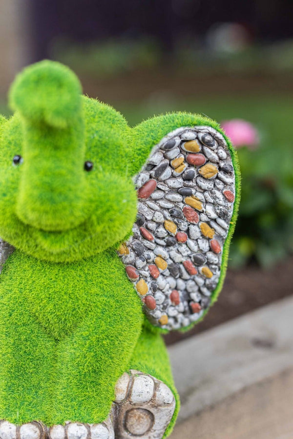 Grass covered elephant ornament displayed outdoors