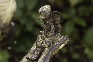 Resin statue of a sitting girl holding a fairy