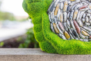 Decorative outdoor snail ornament amongst flowers