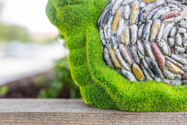 Decorative outdoor snail ornament amongst flowers