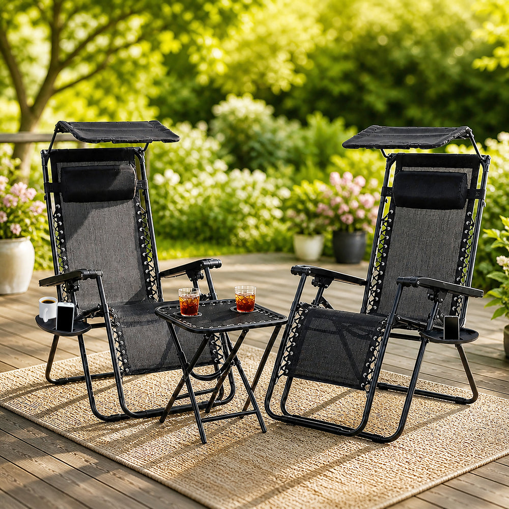 Set of two black folding sun loungers with drinks table