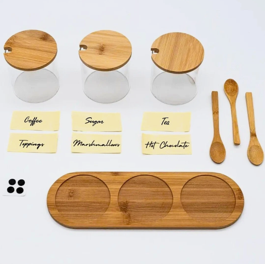 Three glass kitchen jars displayed on a wooden tray