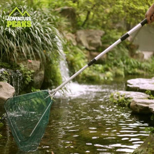 Telescopic aluminium fishing landing net extended for use.