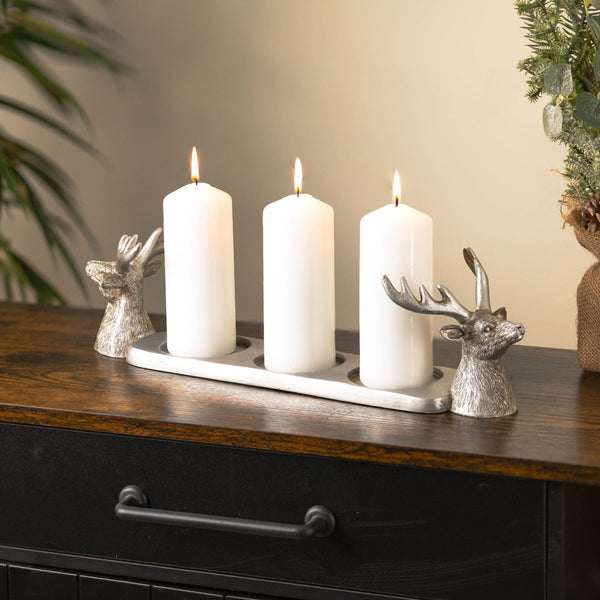 Silver stag ornament holding three pillar candles