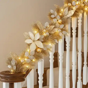 Decorative Christmas garland with lights on a staircase railing.