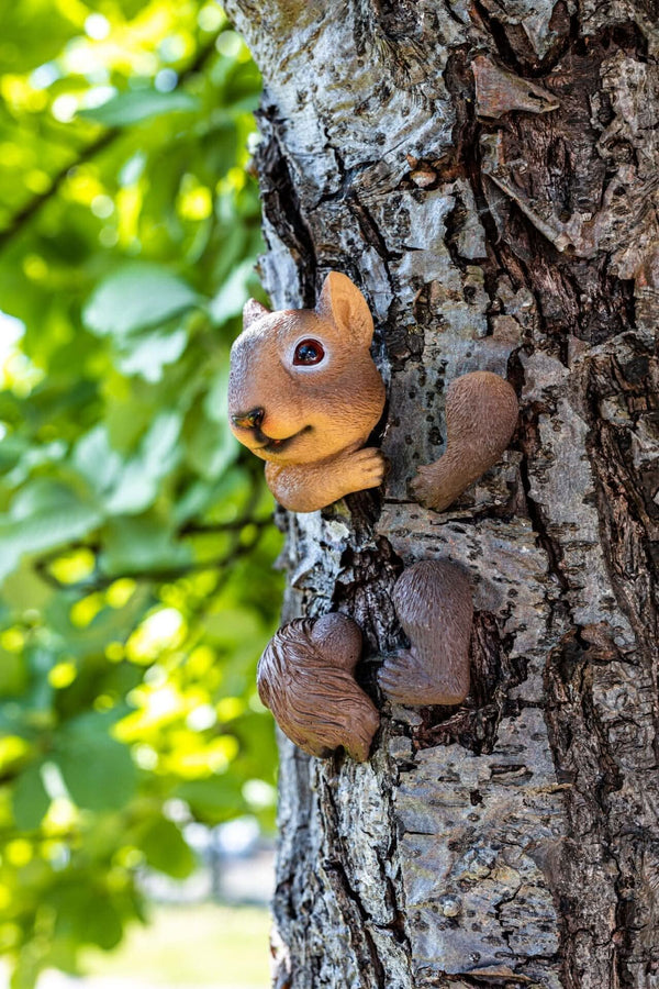 Squirrel ornament peeking from behind tree