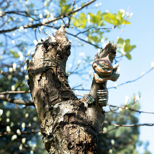 Resin goblin peeking from behind a tree