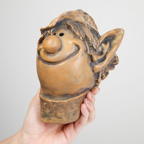 Whimsical elf decoration peeking from tree trunk