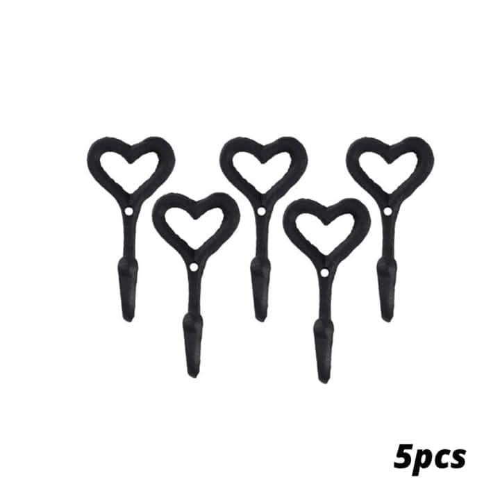 Five black heart-shaped hooks on a textured brown surface 