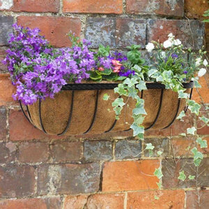 Black wall mounted flower trough with natural coco liner.